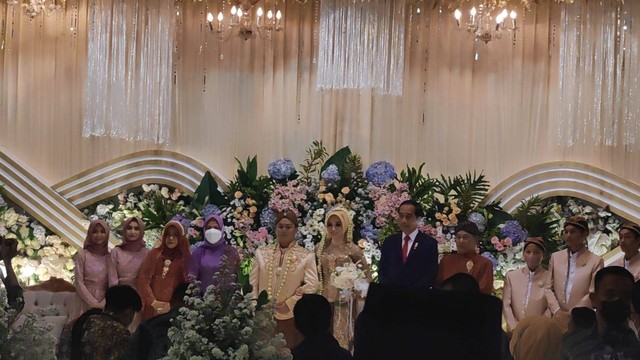 Presiden Jokowi berfoto bersama mempelai saat menghadiri pernikahan putra guru mengajinya di Graha Setyowati, Gentan, Kecamatan Baki, Sukoharjo, Minggu (05/06/2022). FOTO: Fernando Fitusia 