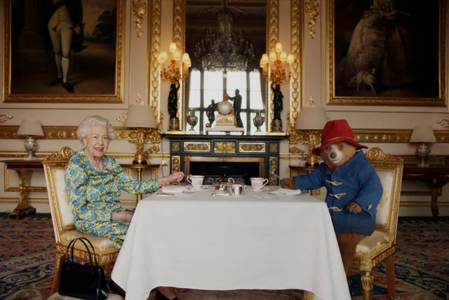 Ratu dan Paddington Bear mengobrol sambil minum teh di klip pembuka konser. Foto: Buckingham Palace/via REUTERS