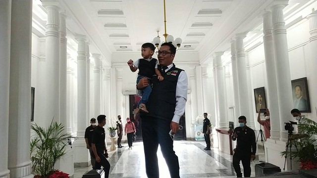 Gubernur Jabar Ridwan Kamil kembali ke Gedung Sate sambil memangku anak ketiganya, Arkana Aidan Misbach.  Foto: Dok. Istimewa