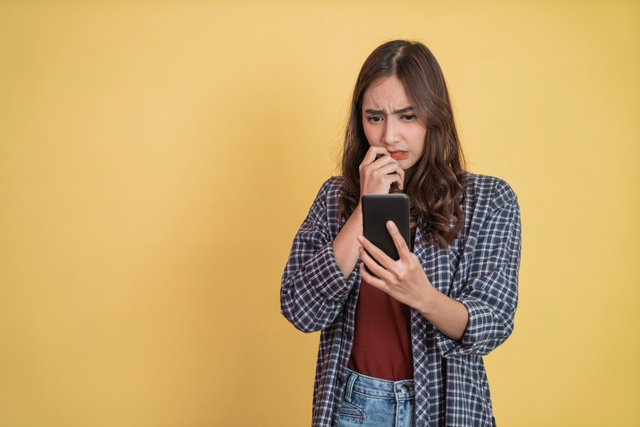 Ilustrasi seseorang yang panik karena terlanjur mengangkat telepon dari oknum penipu. Foto: Shutterstock