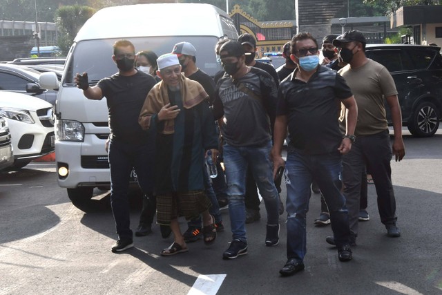Sejumlah polisi mengamankan kedatangan petinggi organisasi Khilafatul Muslimin, Abdul Qadir Baraja (tengah) saat tiba di Polda Metro Jaya, Jakarta, Selasa (7/6/2022).  Foto: Aditya Pradana Putra/ANTARA FOTO