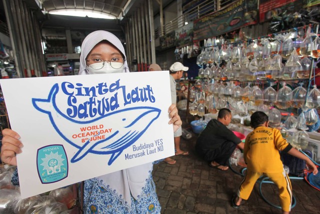 Pelajar SMP Muhammadiyah 5 Pucang Surabaya melakukan aksi dengan membentangkan poster di Pasar Ikan Hias Gunung Sari, Surabaya, Jawa Timur, Rabu (8/6/2022). Foto: Didik Suhartono/ANTARA FOTO