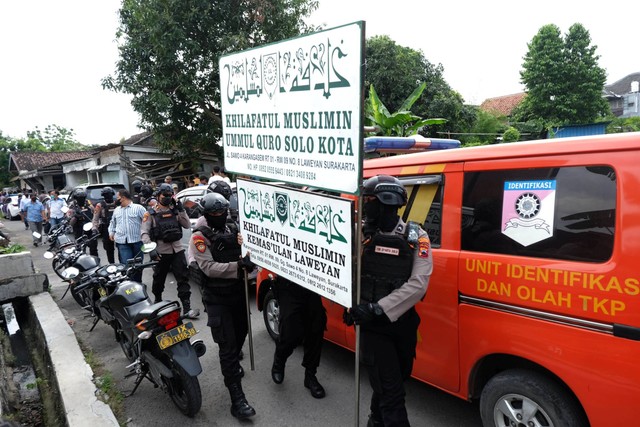 Polisi menurunkan papan bertulis Khilafatul Muslimin dari rumah warga sekaligus kantor cabang kelompok tersebut di Solo, Jawa Tengah, Kamis (9/6/2022). Foto: Maulana Surya/ANTARA FOTO