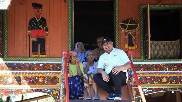 Bupati Dharmasraya Sutan Riska Tuanku Kerajaan bersama warga dan tengah duduk di salam satu Rumah Gadang yang ada di Dharmasraya, Sumatera Barat. Foto: dok Humas Pemkab