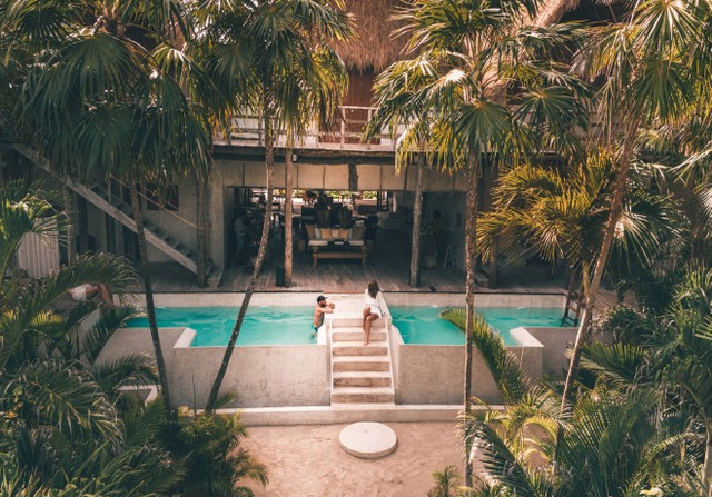 rekomendasi villa Jogja dekat pantai. sumber foto : unsplash/ pria dan wanita berenang di villa.