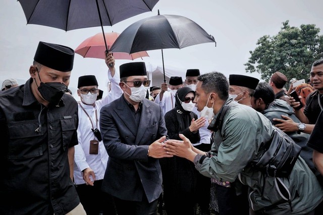 Gubernur Jawa Barat Ridwan Kamil dan Atalia menyapa dan menyalami warga yang datang ke lokasi kawasan pemakaman Eril usai menyelesaikan proses pemakaman di Cimaung, Banjaran, Kabupaten Bandung, Senin (13/6/2022). Foto: Jamal Ramadhan/kumparan