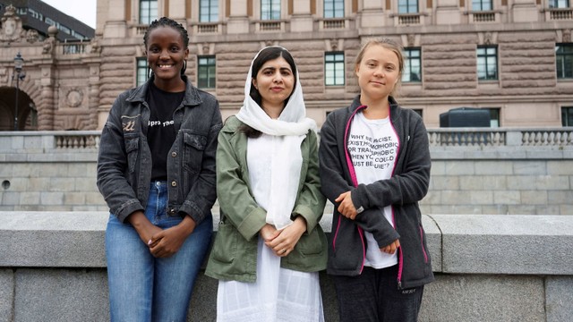 Aktivis iklim Uganda Vanessa Nakate, pemenang hadiah Nobel perdamaian Malala Yousafzai dan aktivis Swedia Greta Thunberg memprotes di luar parlemen Swedia, di Stockholm, Swedia, Jumat (10/6/2022). Foto: Philip O'Connor/Reuters