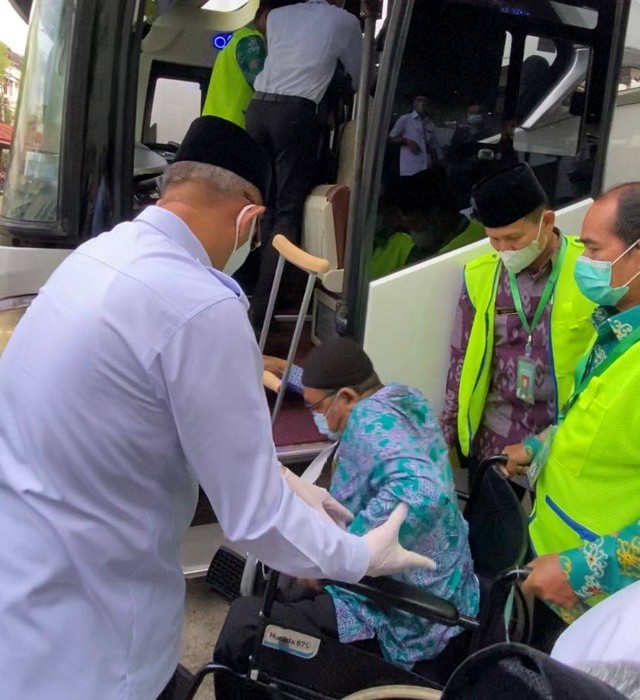 Gubernur Sutarmidji memapah calon jemaah haji Kalbar saat masuk ke bus. Foto: Teru/Hi!Pontianak
