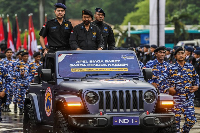 Ketua Umum Partai NasDem Surya Paloh (tengah) didampingi Ketua Umum Garda Pemuda NasDem Prananda Surya Paloh (kiri) meninjau pasukan yang mengikuti Apel Siaga Baret di Parkir Timur Senayan, Kompleks Gelora Bung Karno, Jakarta, Rabu (15/6/2022). Foto: Galih Pradipta/Antara Foto