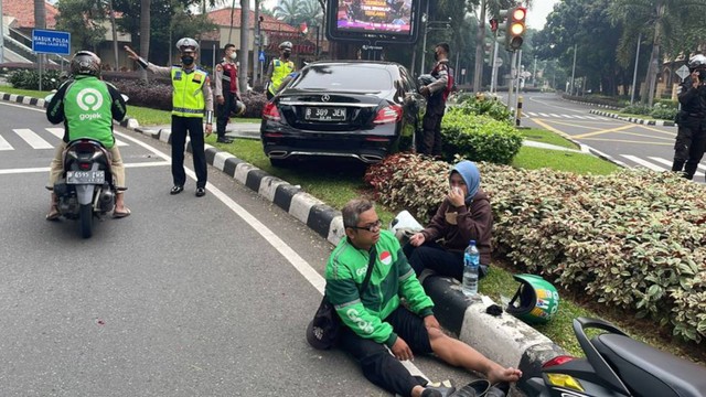Ojol terduduk setelah terlibat kecelakaan dengan pengendara Mercy di SCBD, Jakarta, Jumat (17/6/2022) pagi.  Foto: Twitter/TMCPoldaMetroJaya