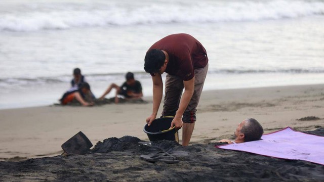 Mengubur tubuh dengan pasir untuk mengobati penyakit. Foto: Suparta/acehkini
