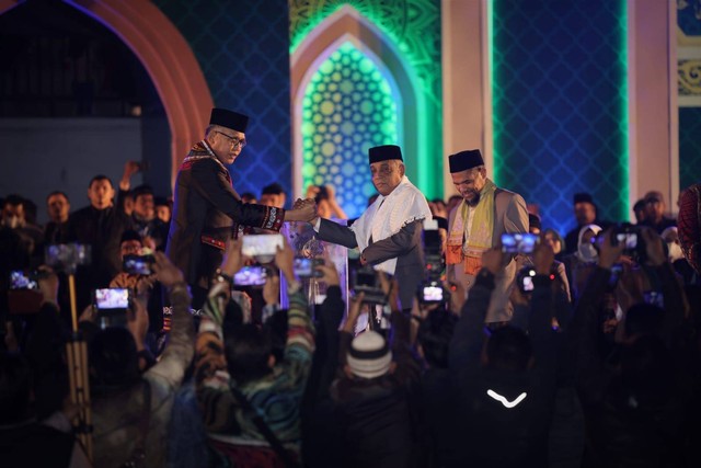 Penyerahan piala bergilir dari Wakil Bupati Aceh Besar Husaini A Wahab kepada Gubernur Aceh Nova Iriansyah pada pembukaan MTQ ke-35 di Bener Meriah. Foto: Abdul Hadi/acehkini