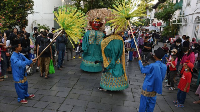 Sejumlah warga menyaksikan kesenian Ondel-ondel dalam memeriahkan hari ulang tahun (HUT) ke-495 Jakarta di kawasan Kota Tua, Jakarta, Minggu (19/6/2022). Foto: Aditya Pradana Putra/Antara Foto