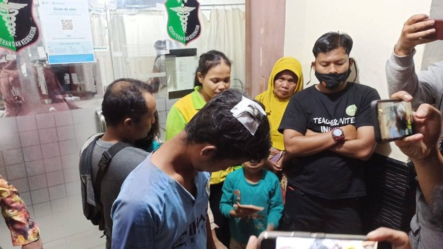 MUHAMMAD Zaki, warga Desa Terantang, Tambang, Kampar, memperlihatkan kepalanya yang sudah dijahit dan diperban, Minggu (19/6/2022), di RS Bhayangkara, Pekanbaru.