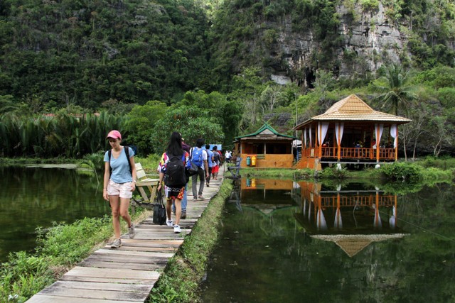 Wisatawan melintas di area desa wisata Rammang-Rammang yang berada dalam kawasan Geopark Maros-Pangkep di Kabupaten Maros, Sulawesi Selatan, Minggu (19/6/2022). Foto: Arnas Padda/ANTARA FOTO