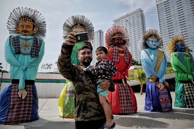 Warga berfoto di depan ondel-ondel yang dipajang di Taman Ismail Marzuki, Jakarta, Selasa (21/6/2022). Foto: Jamal Ramadhan/kumparan