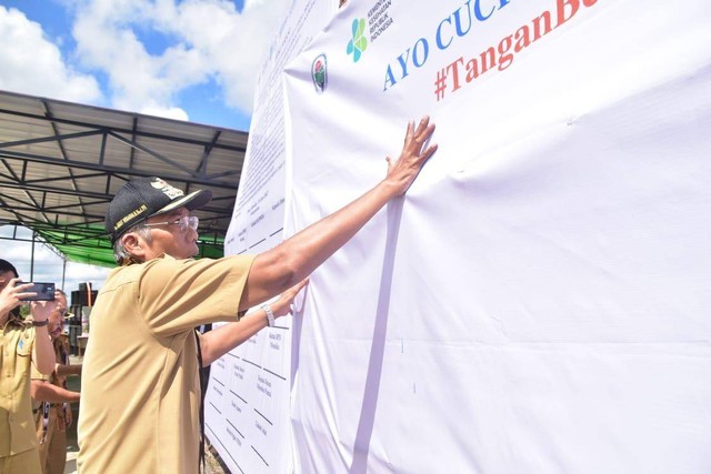 Bupati Sintang, Jarot Winarno, menempelkan cap telapak tangan sebagai kampanye mencuci tangan menggunakan sabun. Foto: Yusrizal/Hi!Pontianak