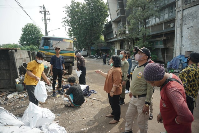 Petugas dari Kelurahan bersama Mahasiswa Kelompok 68 KKN Tematik UPNVJT membersihkan dan merapikan area Crane Putar di Jalan Kalimas Timur Kelurahan Nyamplungan, Minggu (15/5/2022). Foto : Selvina