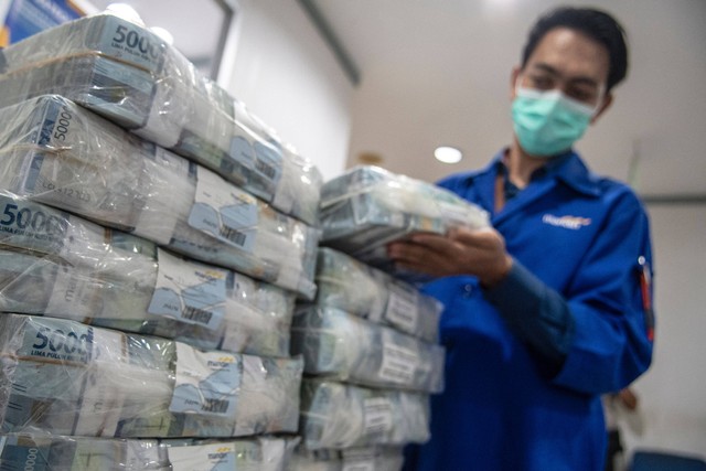 Petugas menyusun tumpukan uang di Cash Pooling Bank Mandiri, Jakarta, Kamis (23/6/2022). Foto: Muhammad Adimaja/ANTARA FOTO