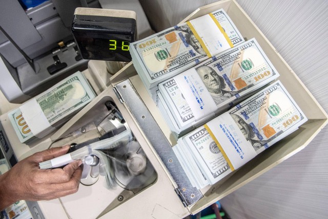 Petugas menghitung uang dolar AS di Cash Pooling Bank Mandiri, Jakarta, Kamis (23/6/2022). Foto: Muhammad Adimaja/ANTARA FOTO