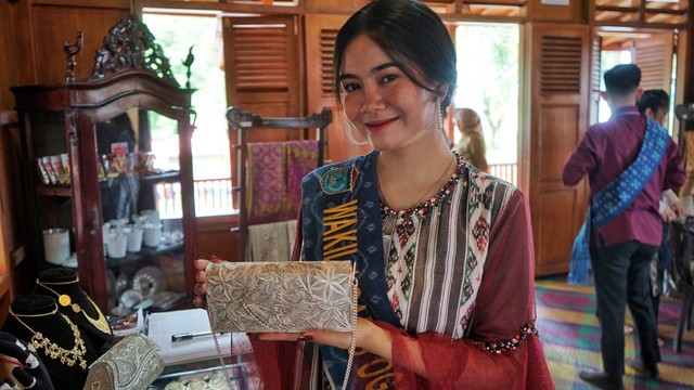 Seorang model yang menunjukkan salah satu produk unggulan berupa aksesoris dari Desa Tanjung Atap Kabupaten Ogan Ilir, Sumatera Selatan saat Festival Anjungan Sumsel 2022 berlangsung, Kamis (23/6) Foto: abp/Urban Id