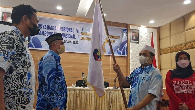 Profesor Ridwan Amiruddin (Ketua Umum Persakmi Periode 2017-2021) memnyerahkan bendera Persakmi sebagai simbol penyerahan estafet kepemimpinan kepada Aminuddin Syam (Ketua Umum Persakmi Periode 2022-2026) saat Munas VI Persakmi, di Surabaya (24/06/2022)