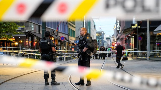Pasukan keamanan berdiri di lokasi di mana beberapa orang terluka dalam penembakan di luar pub London di pusat Oslo, Norwegia, Sabtu (25/6/2022). Foto: Javad Parsa/NTB/via REUTERS