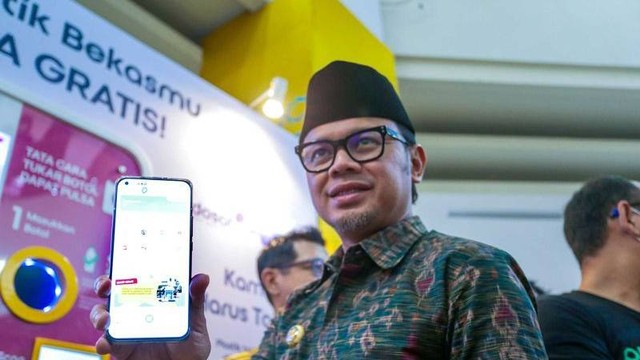 Wali Kota Bogor Bima Arya Sugiarto menunjukan menggandeng perusahaan operator seluler membuat terobosan dalam mengurangi sampah botol plastik dengan menukarnya menjadi pulsa senilai Rp10.000 per botol. Foto: Linna Susanti/ Antara