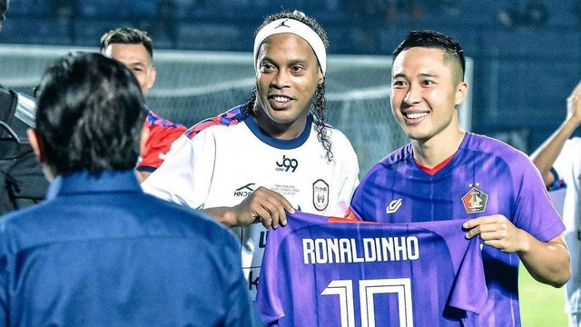 Pemain Persik Kediri Arthur Irawan berjabat tangan dengan Ronaldinho.
 Foto: Instagram/@arthurirawan