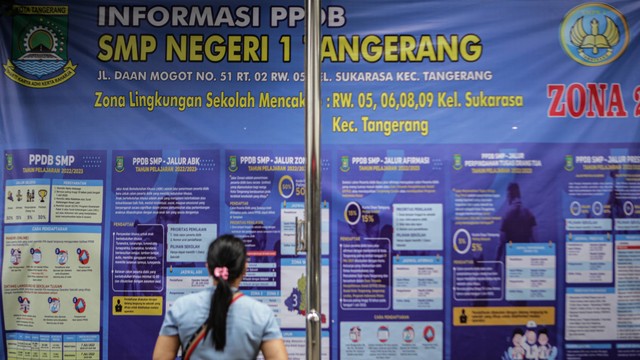 Wali murid calon peserta didik melihat informasi tentang pendaftaran Penerimaan Peserta Didik Baru (PPDB) 2022 di SMPN 1 Kota Tangerang, Banten, Senin (27/6/2022). Foto: Fauzan/ANTARA FOTO