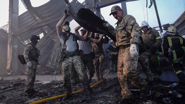 Tim penyelamat sibuk bekerja di lokasi pusat perbelanjaan yang terkena serangan rudal Rusia di Kremenchuk, wilayah Poltava, Ukraina, Senin (27/6/2022). Foto: Anna Voitenko/Reuters