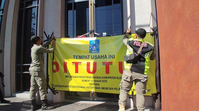 Satpol PP Sleman menutup outlet Holywings Jogja yang berada di Jalan Magelang, Kabupaten Sleman, Rabu (29/6/2022). Foto: Arfiansyah Panji Purnandaru/kumparan