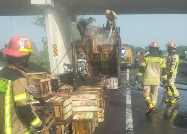 Petugas memadamkan kendaraan pick up pengangkut buah-buahan yang terbakar di tol Cipali KM 81+900 arah Jakarta.(Juan)