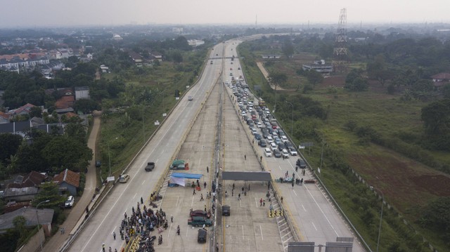 Foto udara sejumlah kendaraan terjebak saat adanya aksi pemblokiran jalan oleh warga di Tol Cimanggis-Cibitung, di Jatikarya, Bekasi, Jawa Barat, Rabu (29/6/2022).  Foto: Fakhri Hermansyah/ANTARA FOTO