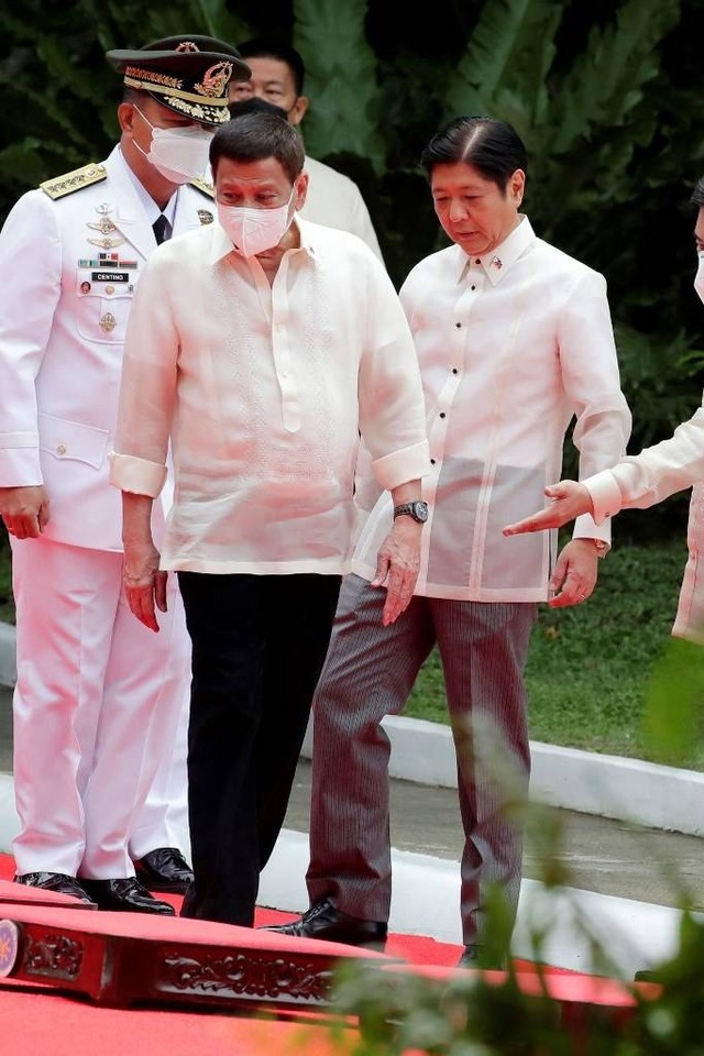 Calon Presiden Filipina yang baru, Ferdinand Marcos Jr (kanan) bersama Presiden Rodrigo Duterte saat mengikuti upacara pelantikan Presiden Filipina di halaman istana kepresidenan Malacanang, Manila, Filipina pada Kamis (30/6/2022). Foto: Francis R. Malasig/Pool/AFP