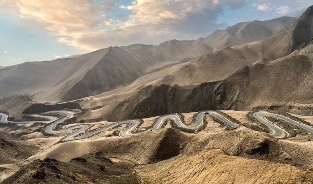 Jalan berliku di pegunungan Pamir. Foto: Tao Jiang/Shutterstock