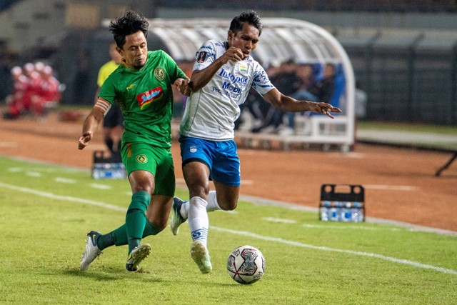 Pemain Persib Bandung Frets Butuan (kanan) berebut bola dengan pemain PSS Sleman Bagus Nirwanto (kiri) saat pertandingan perempat final Piala Presiden 2022 di Stadion Si Jalak Harupat, Kabupaten Bandung, Jawa Barat, Jumat (1/7/2022).  Foto: M Agung Rajasa/ANTARA FOTO