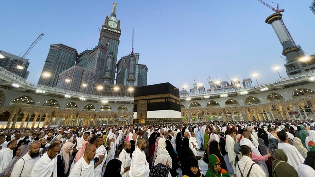 Jemaah haji mengelilingi Ka'bah dan berdoa di Masjidil Haram pada 1/7/2022. Terlihat crane/derek dari kejauhan. Hingga kini Masjidil Haram terus diperluas agar bisa menampung jemaah lebih banyak. Foto: Mohammed Salem/REUTERS