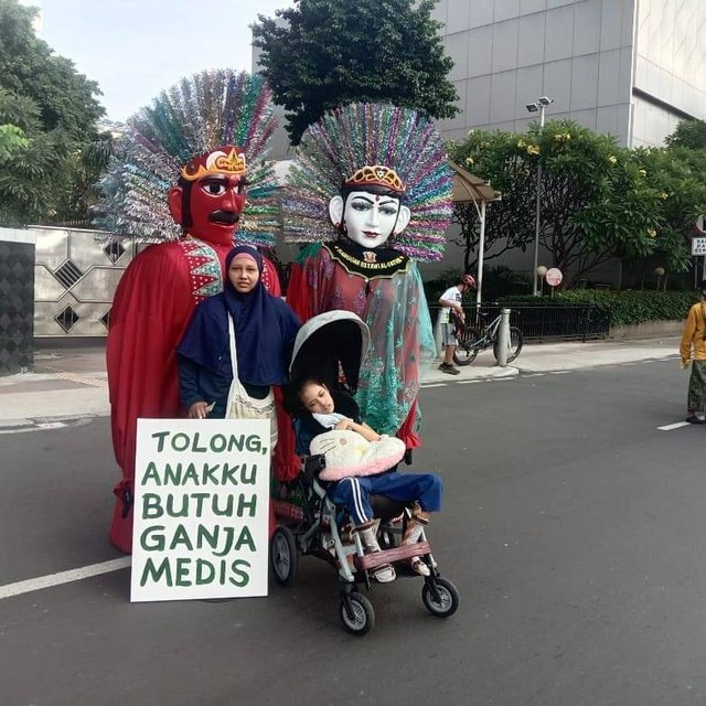 Santi Warastuti, bersama anaknya Pika, membawa poster tuntutan ganja medis dilegalkan di acara Car Free Day (CFD) Jakarta. Foto: Instagram/@santiwarastutisanti