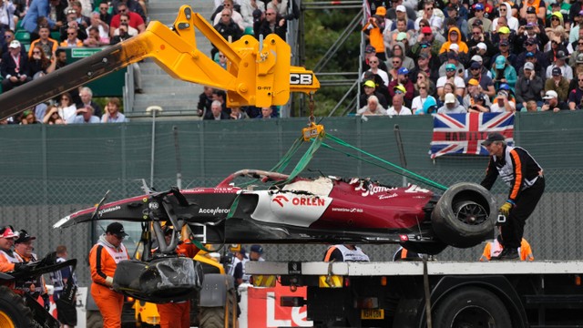 Proses evakuasi mobil balap milik Zhou Guanyu yang mengalami kecelakaan dalam ajang Formula Satu di sirkuit Silverstone, Inggris, Minggu (3/7/2022). Foto: Ben STANSALL/AFP