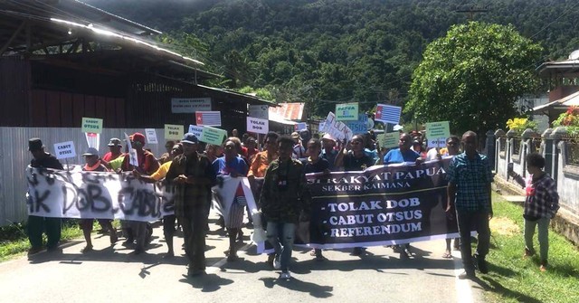 Pendemo saat longmarch, dengan membawakan pamflet dan spanduk berisikan penolakan DOB, Perpanjangan Otsus dan Dukung Referendum