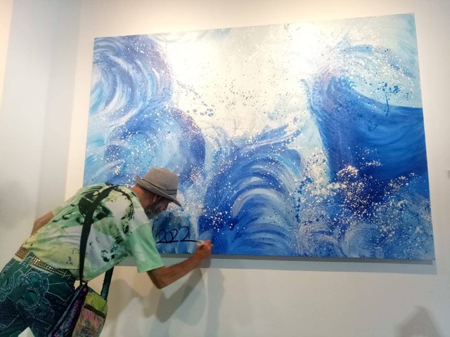 Seniman Amerika Serikat Yaari Rom menorehkan tanda-tangan di salah-satu karyanya yang dipamerkan di Park 23 Gallery & Creative Hub, Tuban Bali - IST