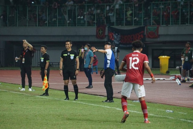 Shin Tae Yong dan jajaran pelatih Timnas U-19 mengenakan rompi biru di pinggir lapangan saat pertandingan Indonesia vs Thailand di laga Piala AFF U-19 di Stadion Patriot Candrabhaga, Bekasi, Rabu (6/7/2022). Foto: Iqbal Firdaus/kumparan