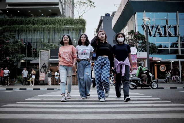 Remaja berpose di area sekitar taman Stasiun MRT Dukuh Atas, Jakarta Pusat, Kamis (7/7/2022). Foto: Jamal Ramadhan/kumparan