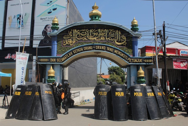 Polisi berjaga di depan gerbang Pondok Pesantren Shiddiqiyyah Ploso saat proses upaya penangkapan Moch Subchi Azal Tsani (MSAT) di Jombang, Jawa Timur, Kamis (7/7/2022). Foto: Syaiful Arif/ANTARA FOTO