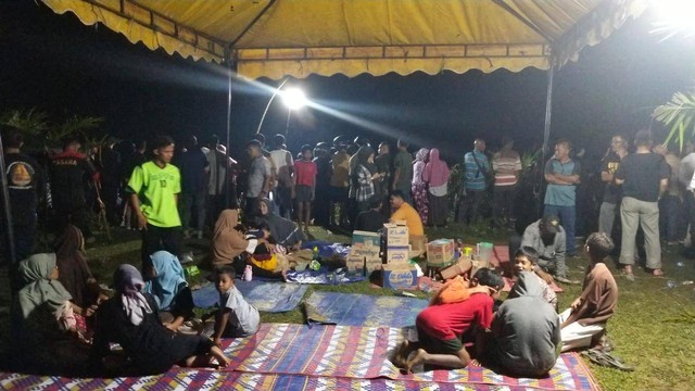 Keluarga korban dan warga duduk di bawah tenda saat mencari tiga orang kakak beradik yang hilang terseret arus sungai Krueng Meureubo, Aceh Barat. Foto: Dok. acehkini