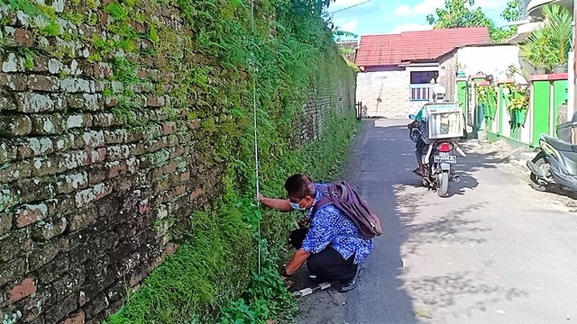 Petugas BPCB Jateng mengukur tembok Ndalem Singopuran, Sukoharjo yang diduga cagar budaya, Jumat (08/07/2022). FOTO: Agung Santoso