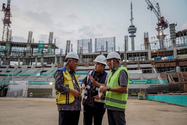 Menteri PUPR Basuki Hadimuljono (kiri) berbincang dengan Menteri BUMN Erick Thohir (tengah) saat meninjau proyek pembangunan Indoor Multifunction Stadium di Kompleks GBK, Senayan, Jakarta, Jumat (8/7/2022).  Foto: Dhemas Reviyanto/ANTARA FOTO
