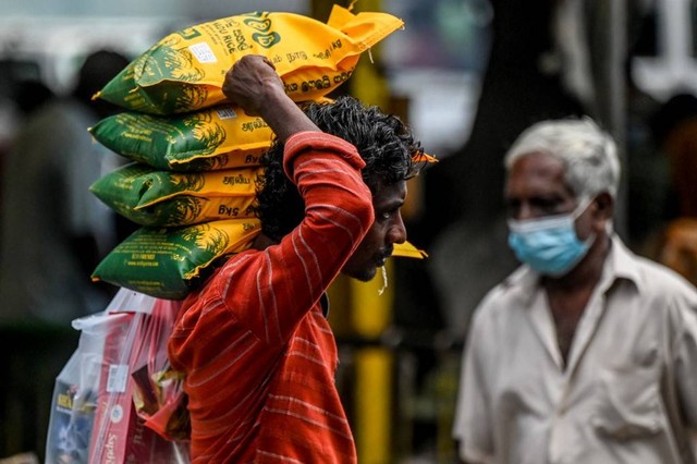 Pekerja mengangkut biji-bijian makanan dan barang-barang penting lainnya di Kolombo, Sri Lanka pada Kamis (12/5/2022). Foto: Ishara S. Kodikara/AFP