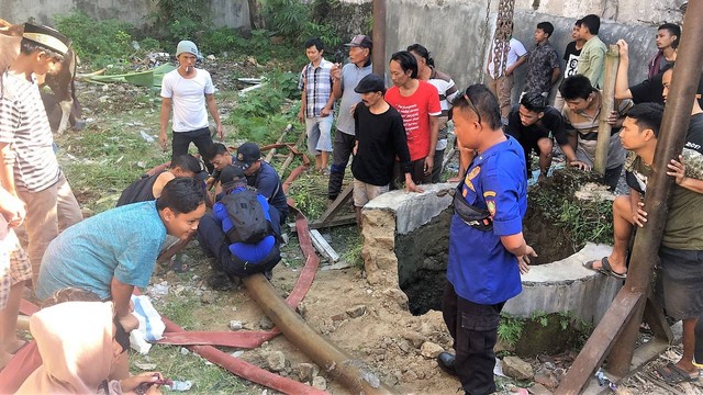 Petugas pemadam kebakaran dan warga menyiapkan evakuasi sapi kurban yang tercebur sumur di Mojosongo, Solo, Minggu (10/09/2022). FOTO: Fernando Fitusia